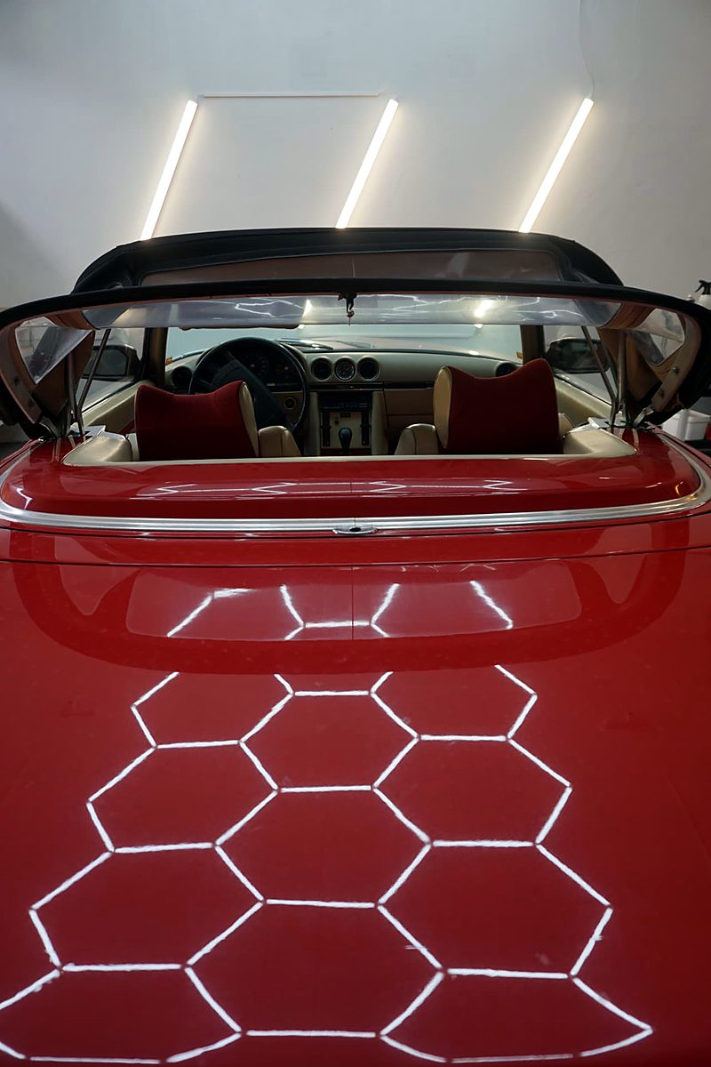 Bakpartiet av en rød klassiker cabriolet i detaljverksted, med tofarget interiør